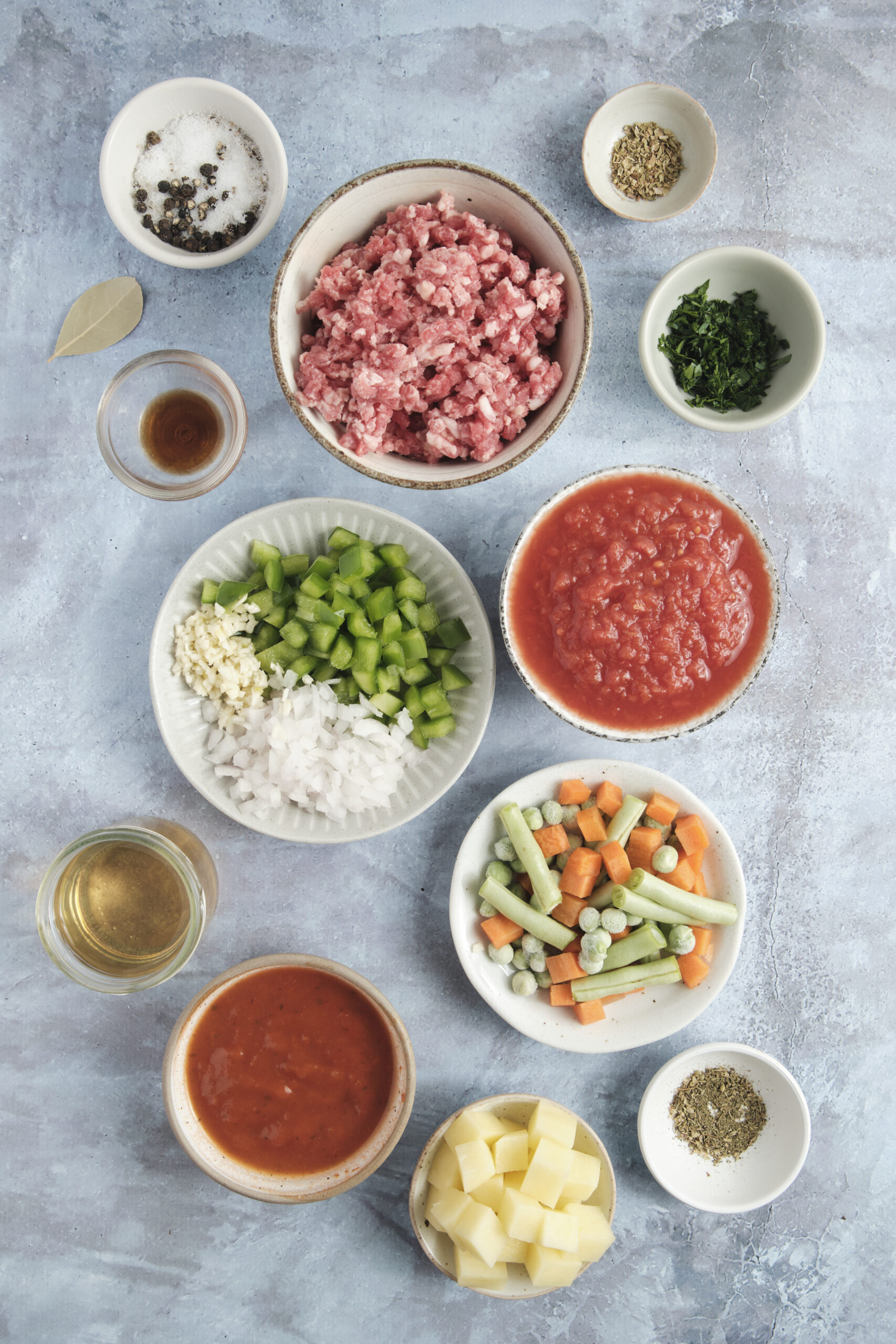 Ingredients for Hamburger Soup: ground beef, diced onion, bell pepper, garlic, potatoes, diced tomatoes, and mixed vegetables.