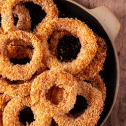 Crispy baked onion rings coated in panko breadcrumbs, served with a side of ketchup.