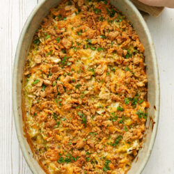 Cabbage casserole in an oval baking dish, with a crunchy cracker and cheese topping.