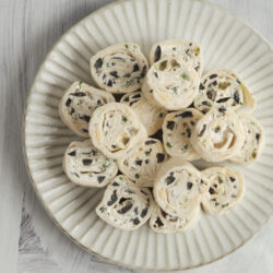 Mexican tortilla roll-ups with black olives and green onions.