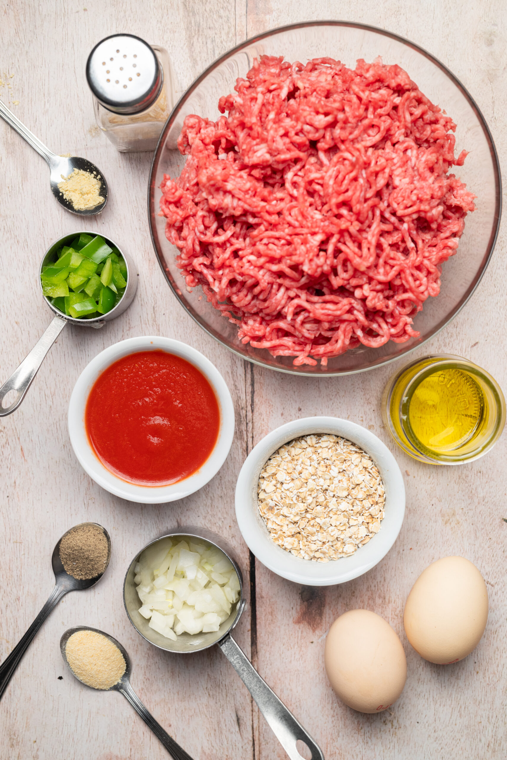 Ingredients for Meatloaf Burgers: ground beef, tomato sauce, quick-cooking oats, eggs, chopped onion, and bell pepper.