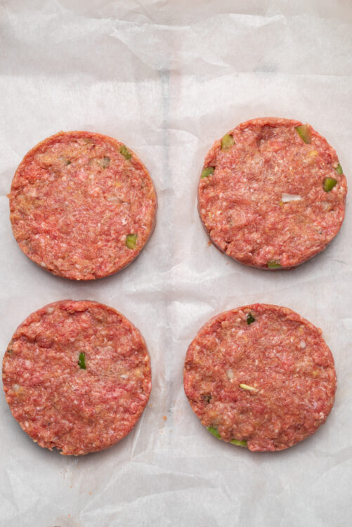Forming raw Meatloaf Burger patties with onion and bell pepper.