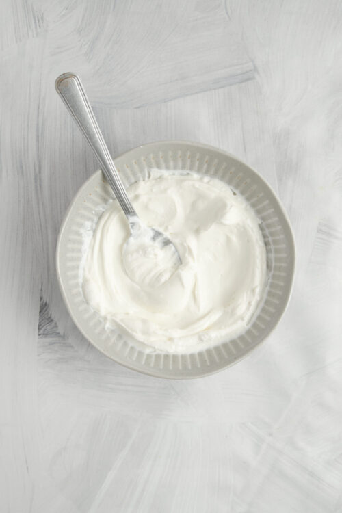 Stirring cream cheese and sour cream together in a bowl for Mexican Tortilla Roll-Ups.