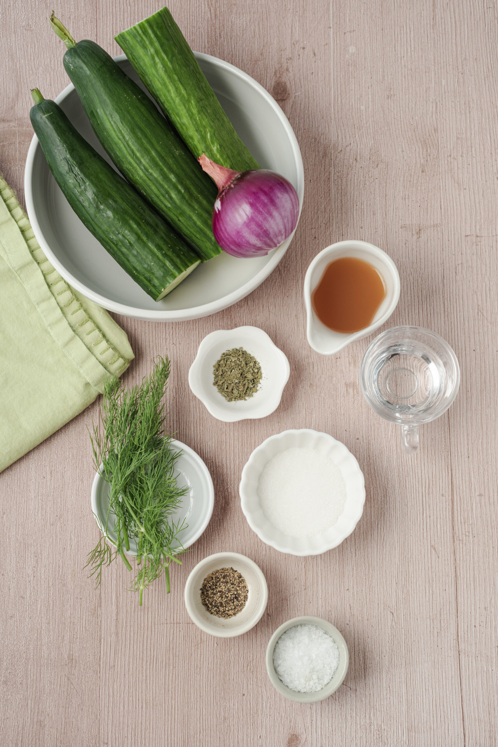Ingredients for cucumber and onion salad: English cucumbers, red onion, apple cider vinegar, water, sugar, dried basil, salt, and fresh dill.