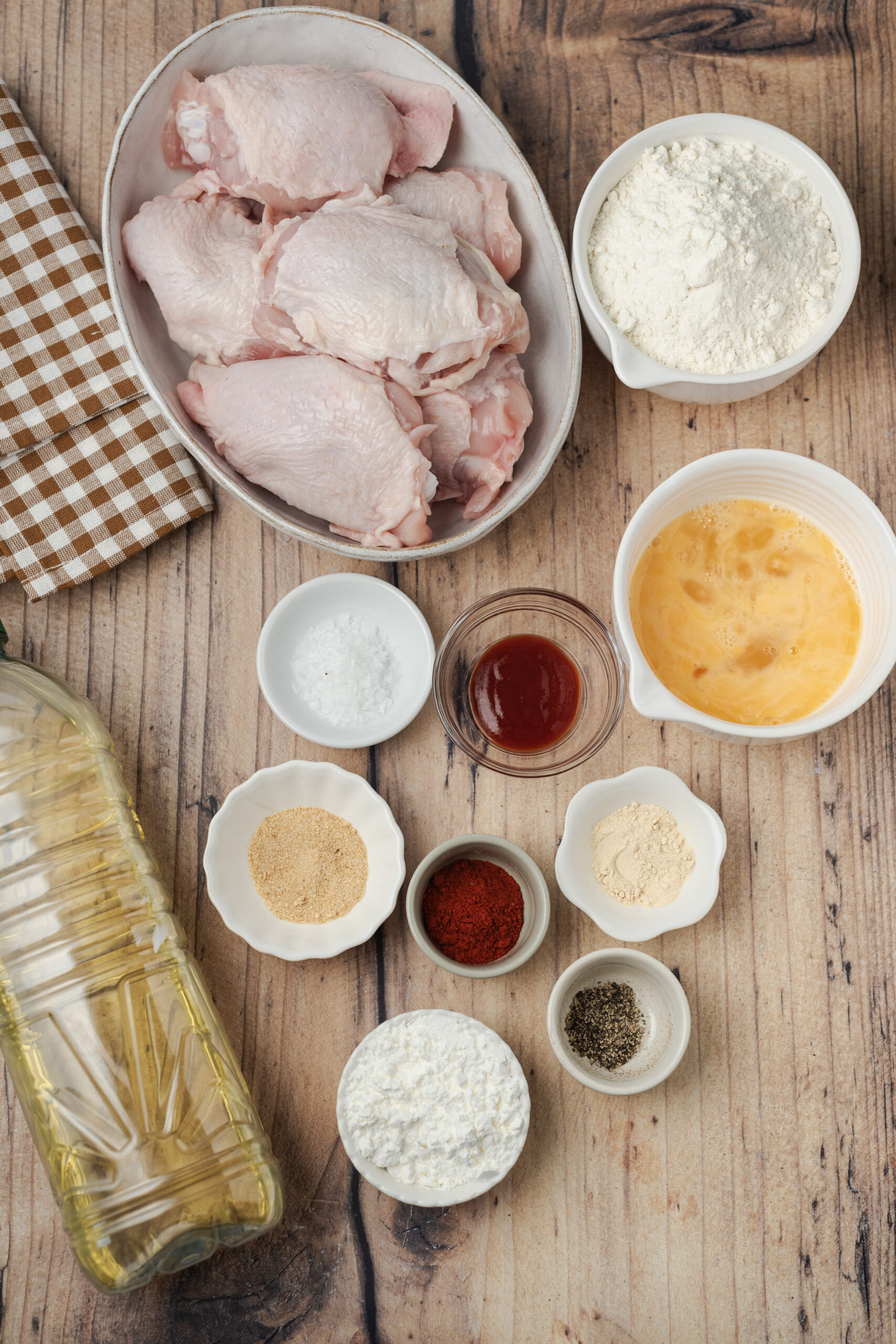 Ingredients for Fried Chicken Recipe: raw chicken pieces, all-purpose flour, cornstarch, beaten eggs, hot sauce, salt, garlic powder, and cooking oil.